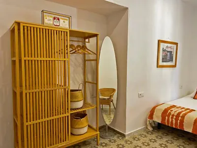 a bedroom with a bed and a shelf with a surfboard at Apartamento Intramuros - Ole Solutions in Jerez de la Frontera