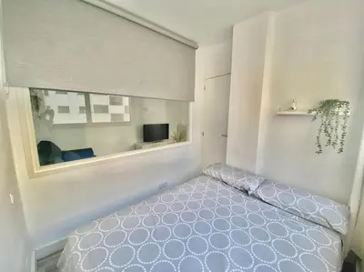a bedroom with a bed and a window at Apartamento nuevo con piscina, temporada in El Puerto de Santa María
