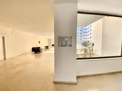 a large white room with a large window in a building at Apartamento nuevo con piscina, temporada in El Puerto de Santa María