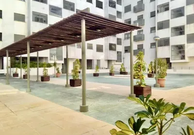 a pavilion with potted plants in front of a building at Apartamento nuevo con piscina, temporada in El Puerto de Santa María