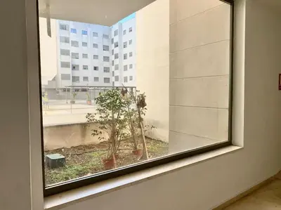 a window in a room with a view of a building at Apartamento nuevo con piscina, temporada in El Puerto de Santa María