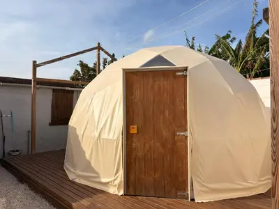 a large dome tent with a wooden door on a deck at ADAMA Glamping in Chiclana de la Frontera