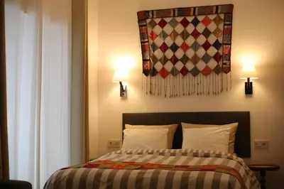 a bedroom with a bed with two lamps and a blanket at Casa de la Fra in Jerez de la Frontera