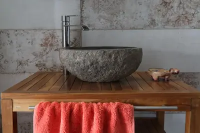 a bathroom with a stone sink on a wooden table at Casa de la Fra in Jerez de la Frontera