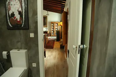 a bathroom with a toilet and a hallway at Casa de la Fra in Jerez de la Frontera