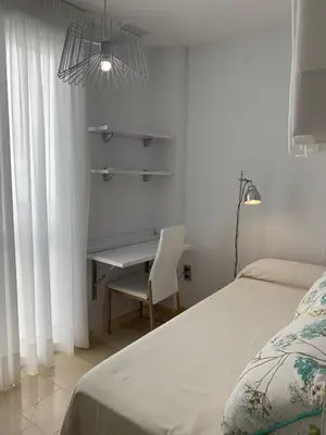 a bedroom with a bed and a desk and a chair at Coral Oro en la Caleta Ha Apartment in Cádiz