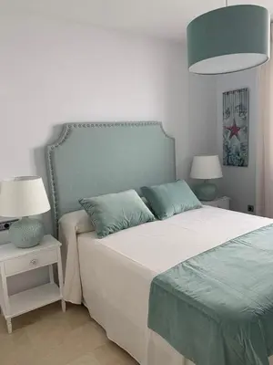a bedroom with a large bed and two lamps at Coral Oro en la Caleta Ha Apartment in Cádiz