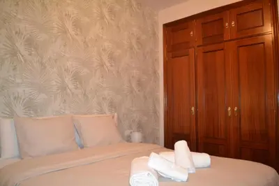 a bedroom with a bed with two towels on it at Apartamento Posidonia Free Parking in Cádiz