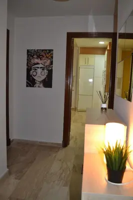 a hallway with a table and a painting on the wall at Apartamento Posidonia Free Parking in Cádiz