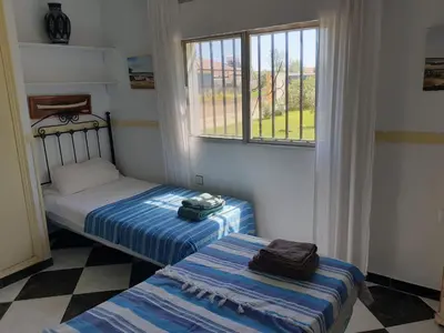 two beds in a room with a window at Casa Francesca, 90 m2, jardin de 1500m2 in Hozanejos