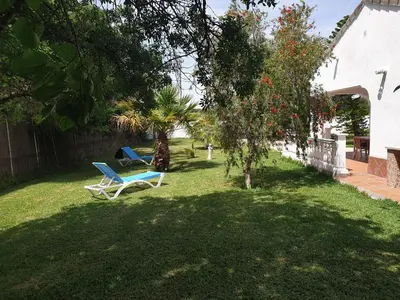 a yard with two chairs and a tree at Casa Francesca, 90 m2, jardin de 1500m2 in Hozanejos
