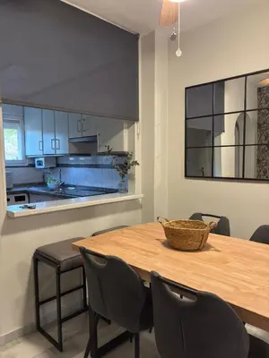a kitchen with a wooden table with chairs and a counter at La Alcazaba de Cristina in El Puerto de Santa María