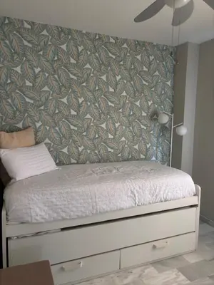 a bedroom with a bed with a wall at La Alcazaba de Cristina in El Puerto de Santa María