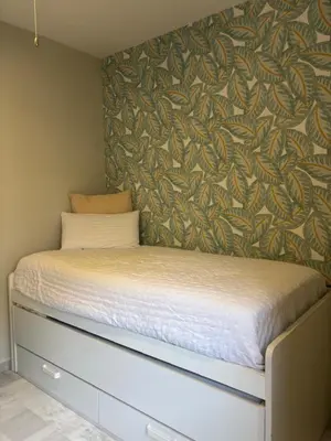 a bed in a bedroom with a wall at La Alcazaba de Cristina in El Puerto de Santa María