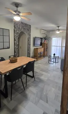 a dining room and living room with a table and chairs at La Alcazaba de Cristina in El Puerto de Santa María