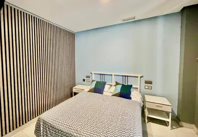 a bedroom with a bed and a striped wall at Hostal Baobab in El Puerto de Santa María