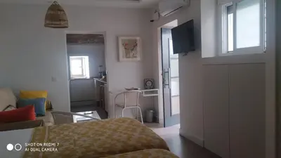 a room with a bed and a living room with a television at Estudio 