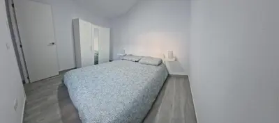 a bedroom with a bed in a white room at Apartamento mi currilla in Sanlúcar de Barrameda