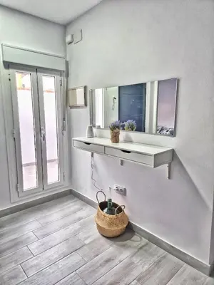 a white room with a shelf and a mirror at Apartamento mi currilla in Sanlúcar de Barrameda