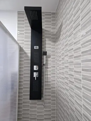 a shower in a bathroom with a black and white wall at Apartamento mi currilla in Sanlúcar de Barrameda