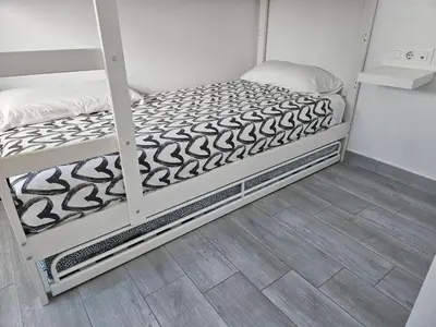a bedroom with two bunk beds and a wooden floor at Apartamento mi currilla in Sanlúcar de Barrameda