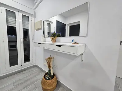 a white room with a white counter and a vase at Apartamento mi currilla in Sanlúcar de Barrameda