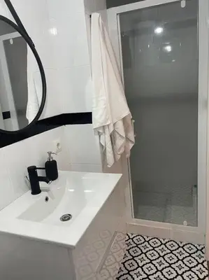 a bathroom with a white sink and a shower at Acogedor apartamento. in Sanlúcar de Barrameda
