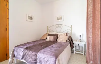 a bedroom with a large bed with a purple blanket at Pet Friendly Home In Algar in Algar
