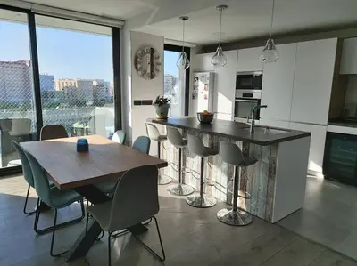 a kitchen with a table and chairs and a kitchen with a view at Torre D'Arenas, playa Victoria, piscina y parking in Cádiz