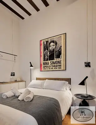 two beds in a bedroom with a movie poster on the wall at La Linda Little Apartments in Cádiz