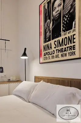 a bedroom with a poster on the wall above a bed at La Linda Little Apartments in Cádiz