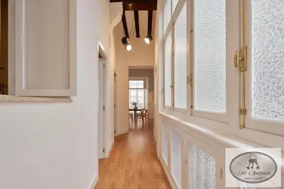 a hallway of a home with white walls and windows at La Linda Little Apartments in Cádiz