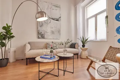 a living room with a couch and two tables at La Linda Little Apartments in Cádiz