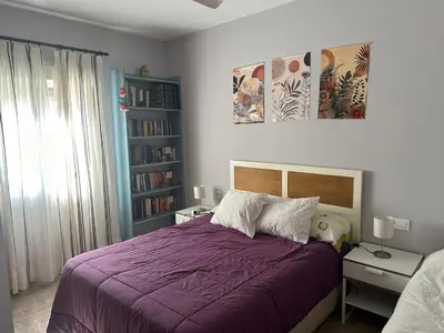 a bedroom with a purple bed and a book shelf at Casa Sampalo in Cádiz