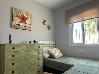 a bedroom with a bed and a dresser and a window at Casa Sampalo in Cádiz