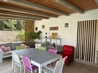 a patio with a white table and colorful chairs at Casa Sampalo in Cádiz