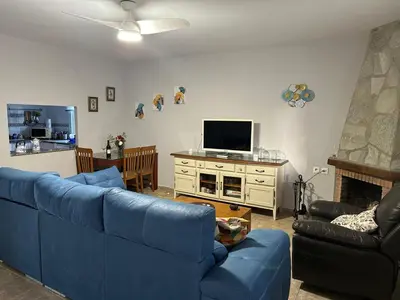 a living room with a blue couch and a tv at Casa Sampalo in Cádiz