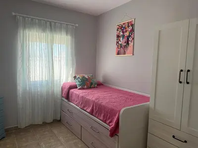 a bedroom with a bed with a pink sheets and a window at Casa Sampalo in Cádiz