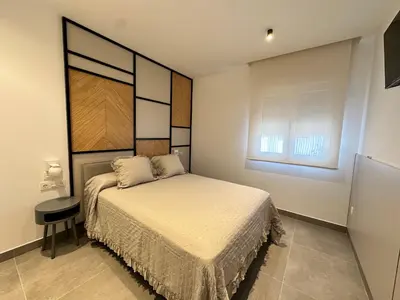 a small bedroom with a bed and a window at Alda & Aljosía in Chiclana de la Frontera
