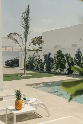 a pineapple sitting on a table next to a pool at Alda & Aljosía in Chiclana de la Frontera