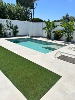 a swimming pool in a yard with grass at Alda & Aljosía in Chiclana de la Frontera