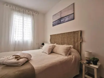 a bedroom with a large bed with a window at Apartamento Pirrado in Sanlúcar de Barrameda