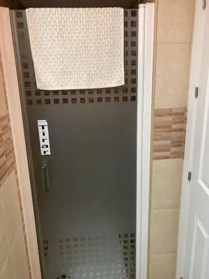 a shower with a glass door in a bathroom at Apartamento Peña de Hita in El Puerto de Santa María
