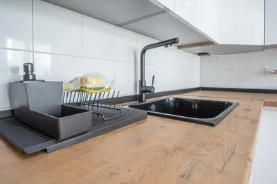 a kitchen with a black sink and a wooden floor at Apartamento El descanso de Julia Augusta - Cadiz in Cádiz