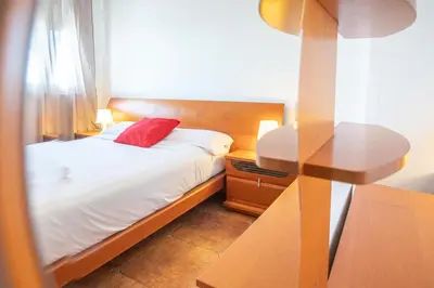 a bedroom with a bed with a red pillow and a table at Apartamento El descanso de Julia Augusta - Cadiz in Cádiz
