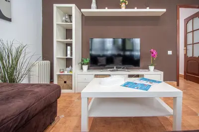 a living room with a white coffee table and a tv at Apartamento El descanso de Julia Augusta - Cadiz in Cádiz