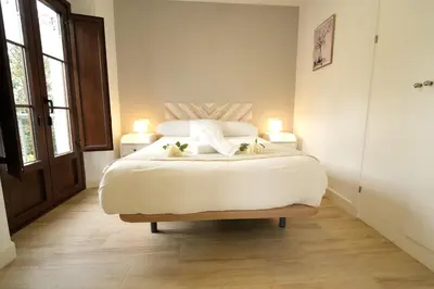 a bedroom with a large white bed with two lamps at Apartamentos Consistorio Live in Jerez de la Frontera