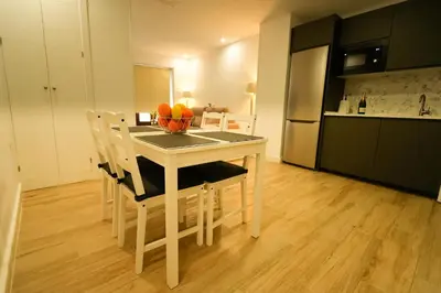 a kitchen with a table with a bowl of fruit on it at Apartamentos Consistorio Live in Jerez de la Frontera
