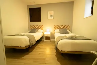 a room with two beds and a table with a lamp at Apartamentos Consistorio Live in Jerez de la Frontera