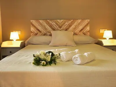 a bed with towels and a bouquet of flowers on it at Apartamentos Consistorio Live in Jerez de la Frontera